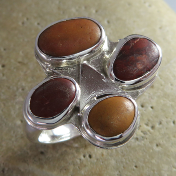 Sterling silver ring set with four red and ochre jasper beach pebbles.